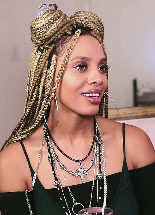 Blonde box braids styled in a half-up bun